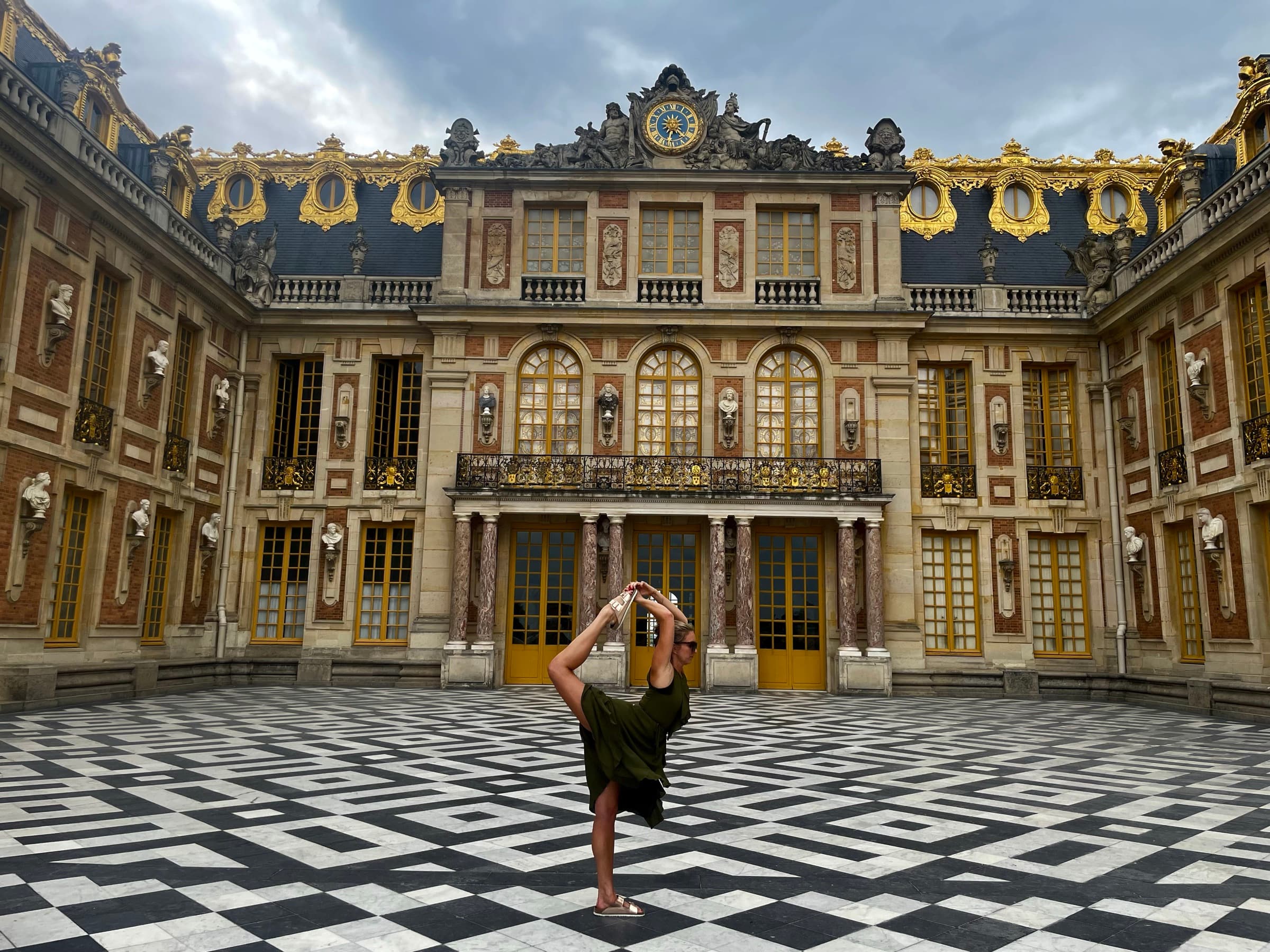 Liz in dancer's pose in the marble courtyard of Versailles