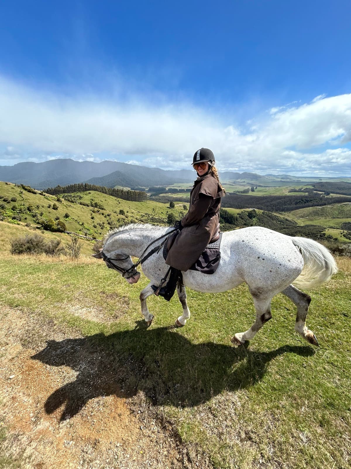 Liz riding through the hills of New Zealand